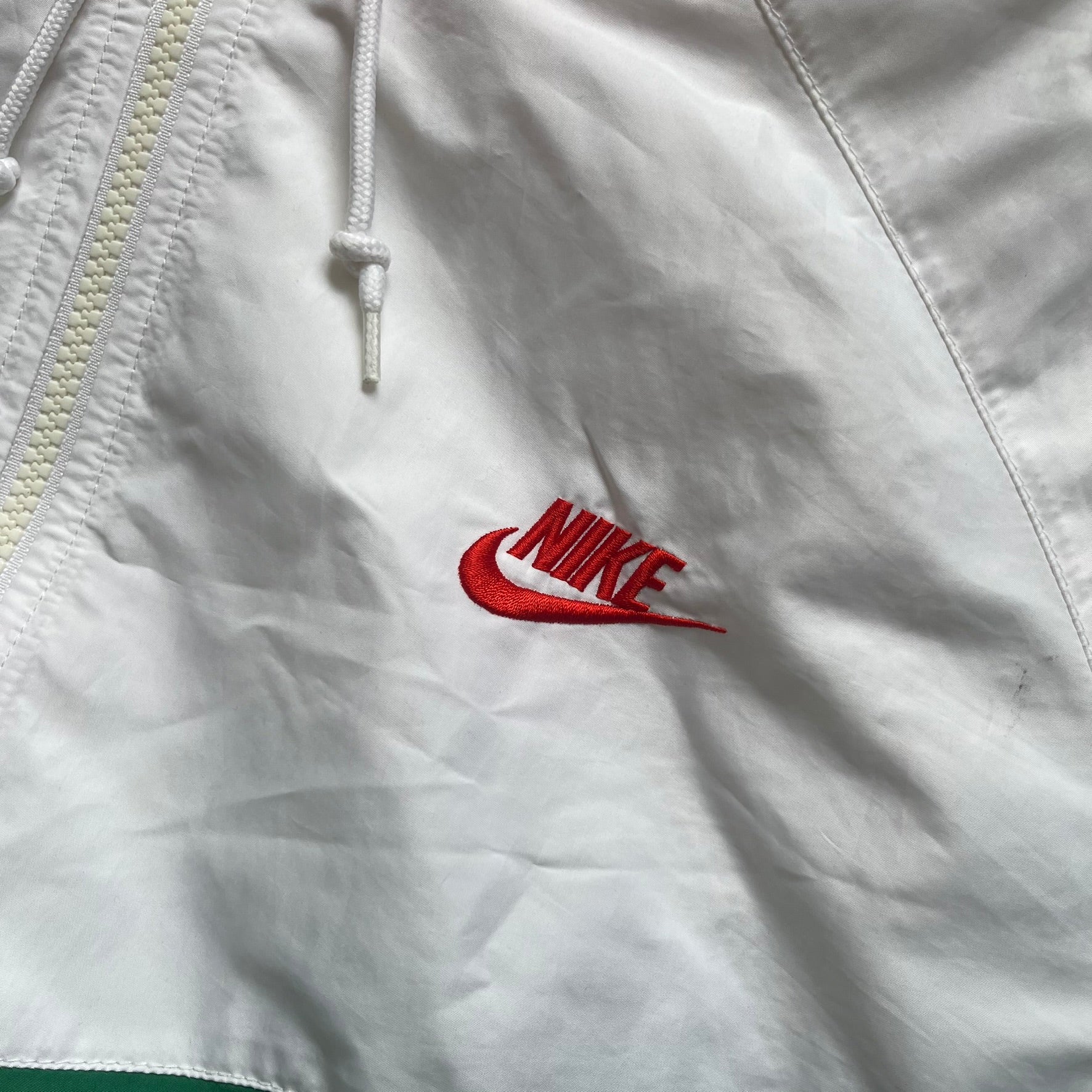 Nike Italy Olympics Split Windbreaker from 2008, created by designer Jarrett Reynolds. Crafted in green/white/red, with a green lower half of the front and sleeves, white upper half and red hood. This innovative jacket can be zipped apart on both sides and merged with other compatible models. Hidden inside, a small Italy flags accent completes the concept.