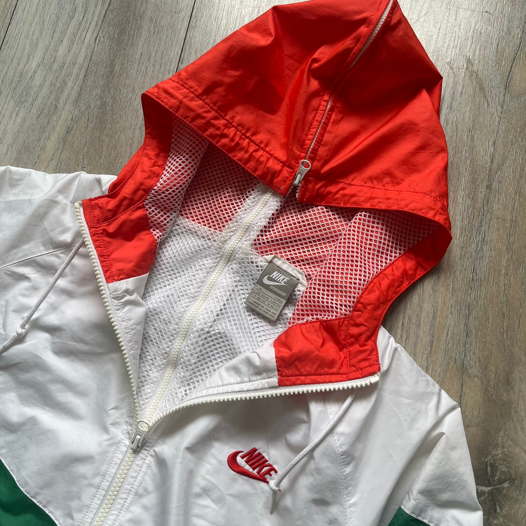 Nike Italy Olympics Split Windbreaker from 2008, created by designer Jarrett Reynolds. Crafted in green/white/red, with a green lower half of the front and sleeves, white upper half and red hood. This innovative jacket can be zipped apart on both sides and merged with other compatible models. Hidden inside, a small Italy flags accent completes the concept.