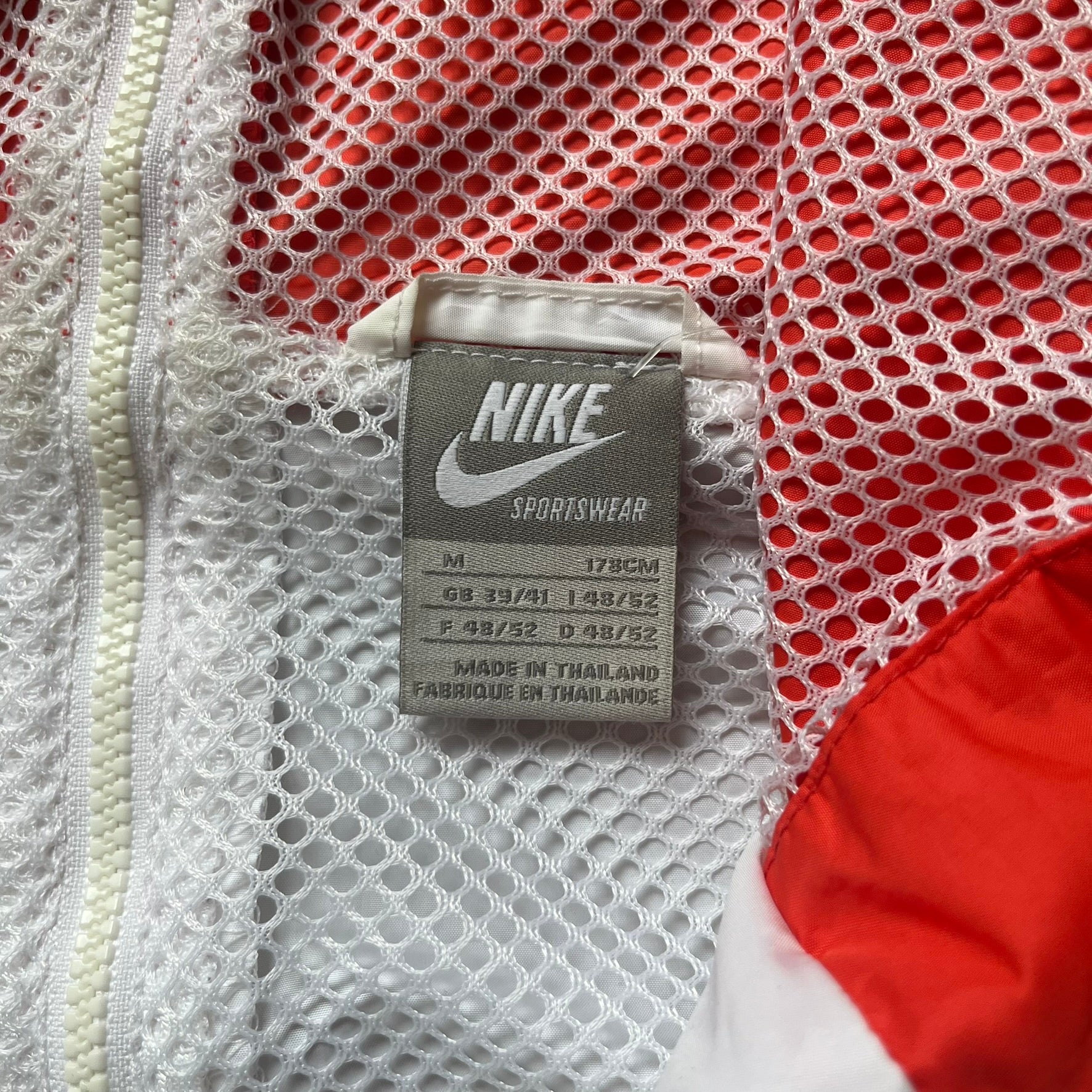 Nike Italy Olympics Split Windbreaker from 2008, created by designer Jarrett Reynolds. Crafted in green/white/red, with a green lower half of the front and sleeves, white upper half and red hood. This innovative jacket can be zipped apart on both sides and merged with other compatible models. Hidden inside, a small Italy flags accent completes the concept.