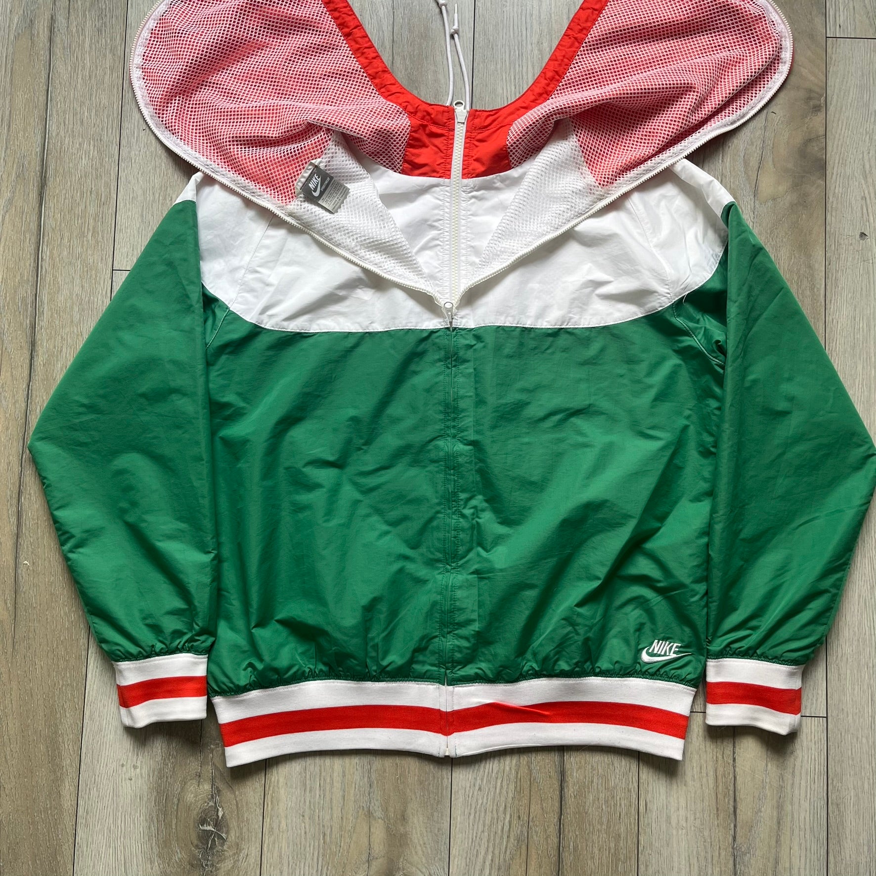 Nike Italy Olympics Split Windbreaker from 2008, created by designer Jarrett Reynolds. Crafted in green/white/red, with a green lower half of the front and sleeves, white upper half and red hood. This innovative jacket can be zipped apart on both sides and merged with other compatible models. Hidden inside, a small Italy flags accent completes the concept.