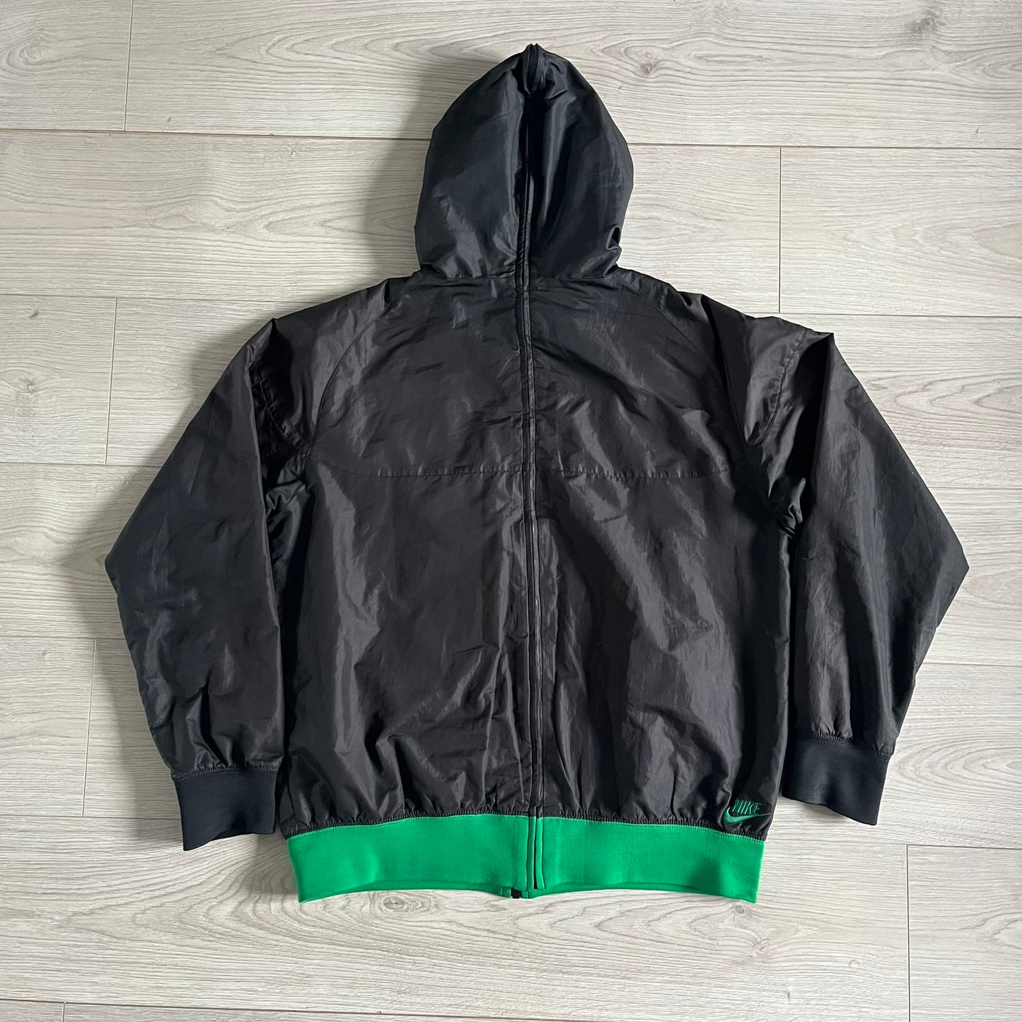 Nike Jamaica Olympics 2008 Split Windbreaker designed by Jarrett Reynolds. Features a black base with a yellow cross on the front inspired by the Jamaican flag. Green bottom hem and details. Dual side zippers allow the jacket to split in half and be combined with other pieces from the collection, with a small Jamaica flag detail inside the pocket.