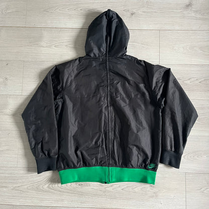 Nike Jamaica Olympics 2008 Split Windbreaker designed by Jarrett Reynolds. Features a black base with a yellow cross on the front inspired by the Jamaican flag. Green bottom hem and details. Dual side zippers allow the jacket to split in half and be combined with other pieces from the collection, with a small Jamaica flag detail inside the pocket.