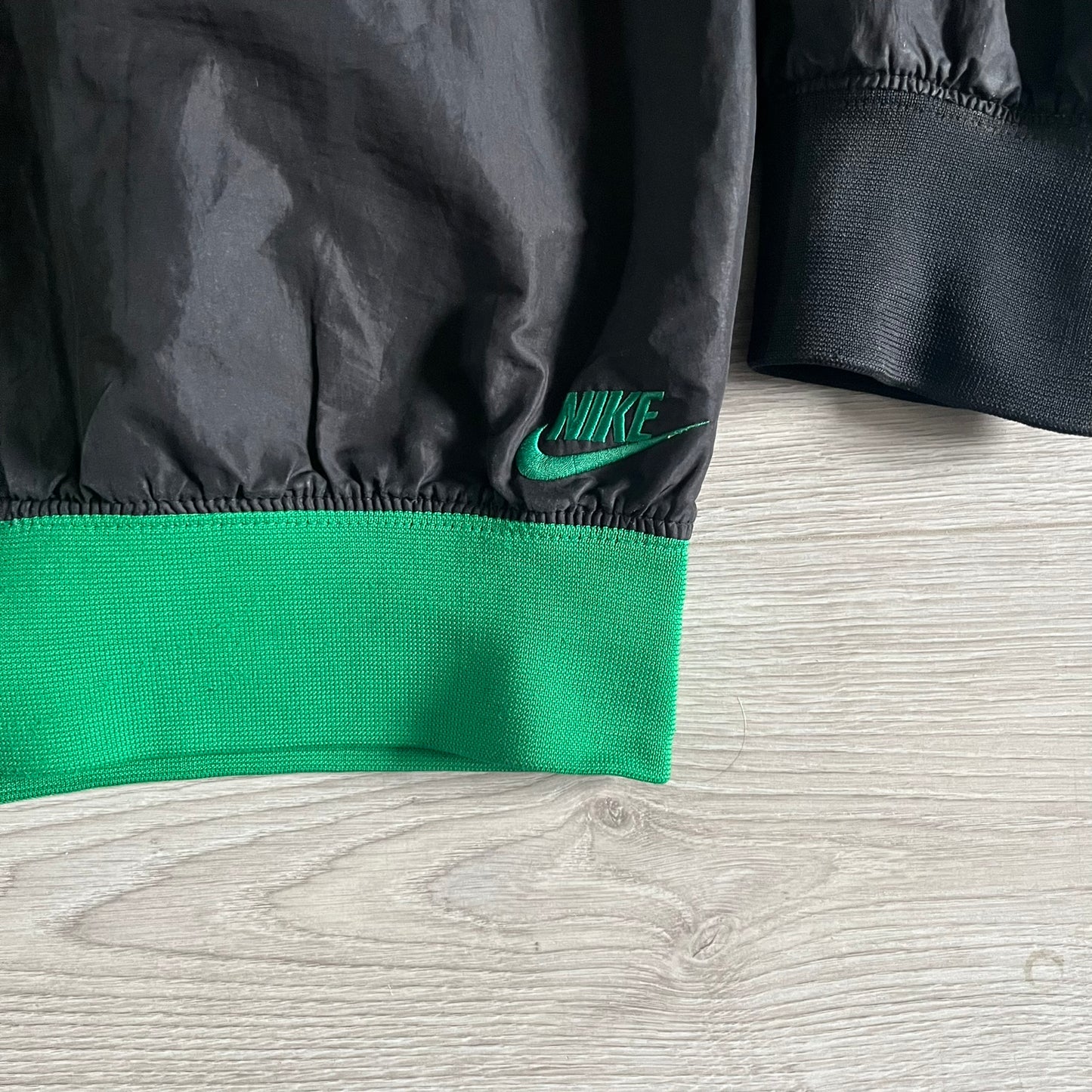 Nike Jamaica Olympics 2008 Split Windbreaker designed by Jarrett Reynolds. Features a black base with a yellow cross on the front inspired by the Jamaican flag. Green bottom hem and details. Dual side zippers allow the jacket to split in half and be combined with other pieces from the collection, with a small Jamaica flag detail inside the pocket.