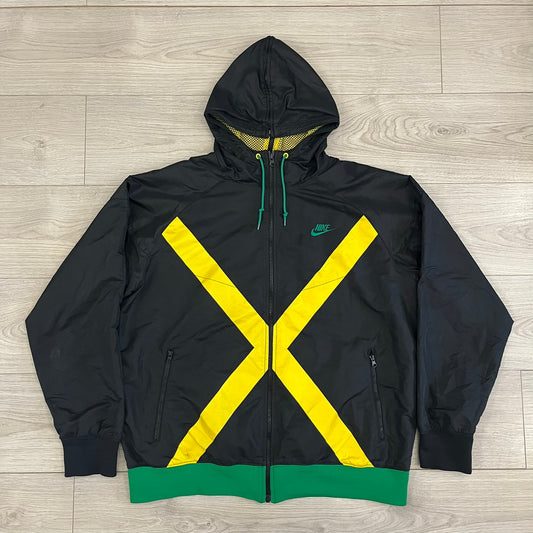 Nike Jamaica Olympics 2008 Split Windbreaker designed by Jarrett Reynolds. Features a black base with a yellow cross on the front inspired by the Jamaican flag. Green bottom hem and details. Dual side zippers allow the jacket to split in half and be combined with other pieces from the collection, with a small Jamaica flags detail inside the pocket.