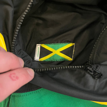 Nike Jamaica Olympics 2008 Split Windbreaker designed by Jarrett Reynolds. Features a black base with a yellow cross on the front inspired by the Jamaican flag. Green bottom hem and details. Dual side zippers allow the jacket to split in half and be combined with other pieces from the collection, with a small Jamaica flags detail inside the pocket.