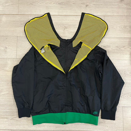 Nike Jamaica Olympics 2008 Split Windbreaker designed by Jarrett Reynolds. Features a black base with a yellow cross on the front inspired by the Jamaican flag. Green bottom hem and details. Dual side zippers allow the jacket to split in half and be combined with other pieces from the collection, with a small Jamaica flags detail inside the pocket.