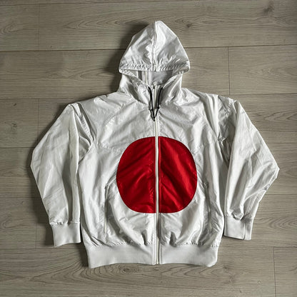 Nike Japan Olympics Split Windbreaker from 2008, created by designer Jarrett Reynolds. Crafted in white with a large red circle representing Japan’s flag, this innovative jacket can be zipped apart on both sides and merged with other compatible models. Hidden inside, a small Japan flag accent completes the concept.