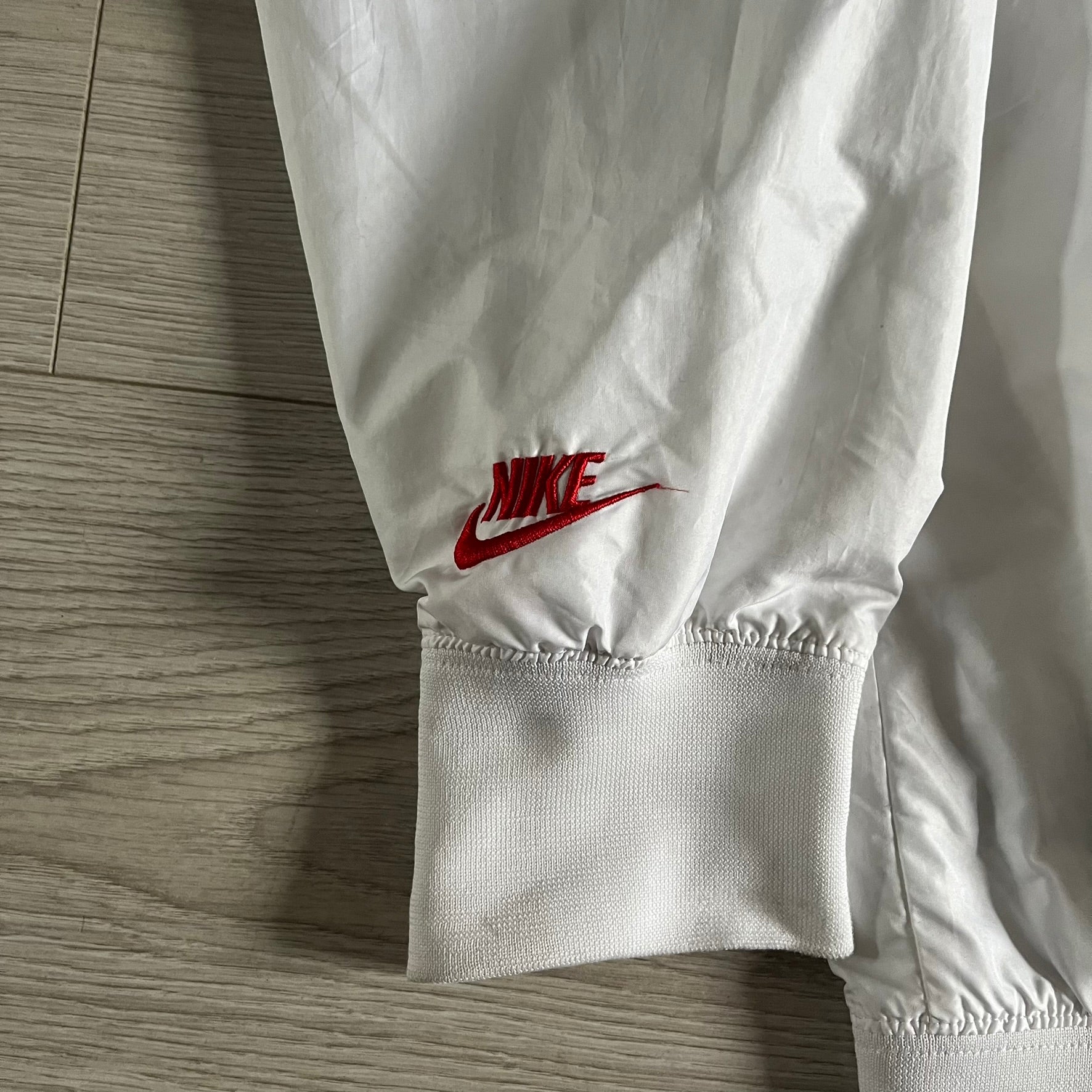 Nike Japan Olympics Split Windbreaker from 2008, created by designer Jarrett Reynolds. Crafted in white with a large red circle representing Japan’s flag, this innovative jacket can be zipped apart on both sides and merged with other compatible models. Hidden inside, a small Japan flag accent completes the concept.