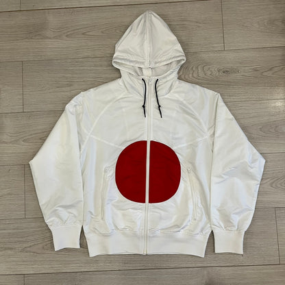 Nike Japan Olympics Split Windbreaker from 2008, created by designer Jarrett Reynolds. Crafted in white with a large red circle representing Japan’s flag, this innovative jacket can be zipped apart on both sides and merged with other compatible models. Hidden inside, a small Japan flags accent completes the concept.