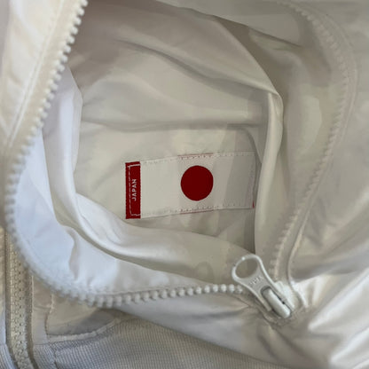 Nike Japan Olympics Split Windbreaker from 2008, created by designer Jarrett Reynolds. Crafted in white with a large red circle representing Japan’s flag, this innovative jacket can be zipped apart on both sides and merged with other compatible models. Hidden inside, a small Japan flags accent completes the concept.