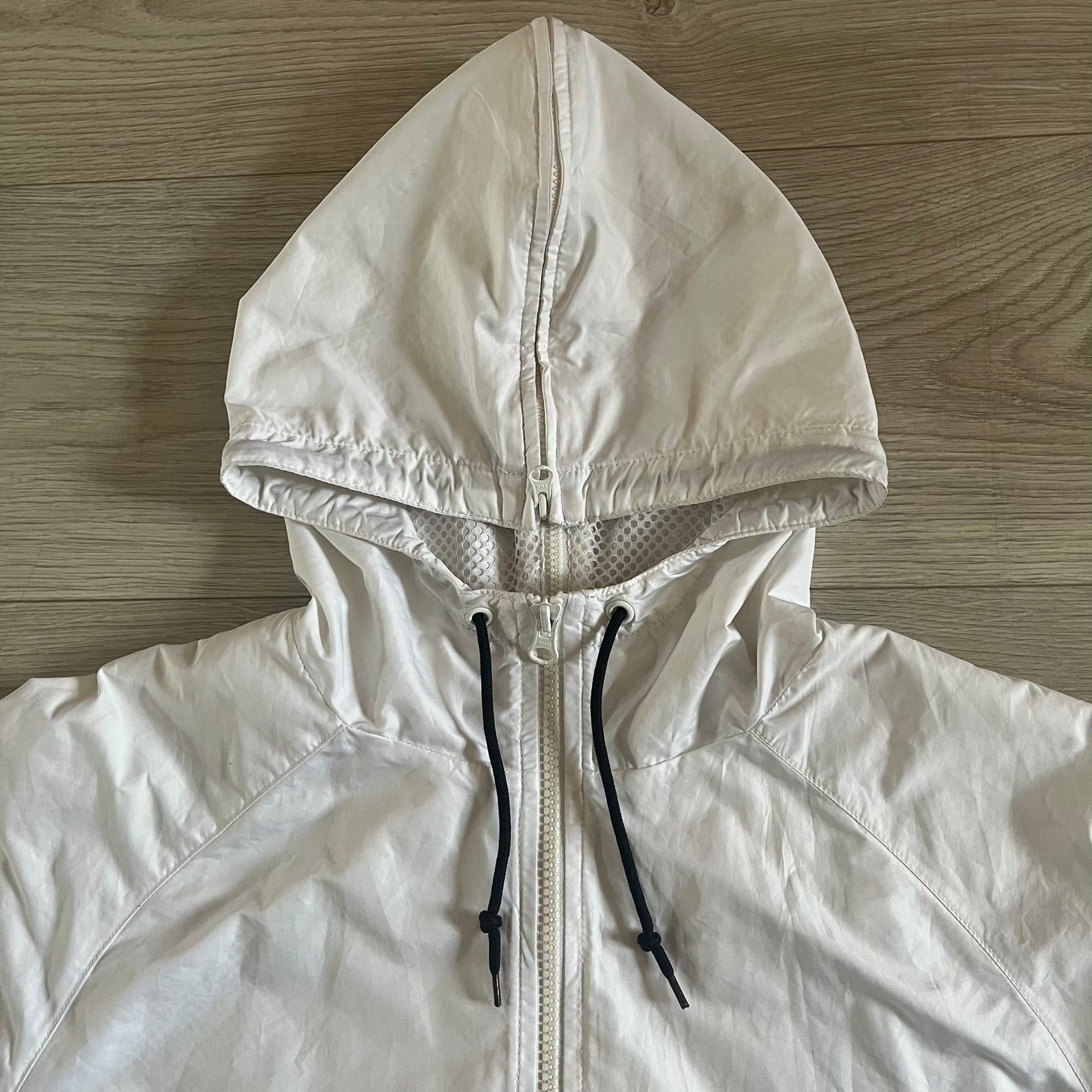 Nike Japan Olympics Split Windbreaker from 2008, created by designer Jarrett Reynolds. Crafted in white with a large red circle representing Japan’s flag, this innovative jacket can be zipped apart on both sides and merged with other compatible models. Hidden inside, a small Japan flags accent completes the concept.