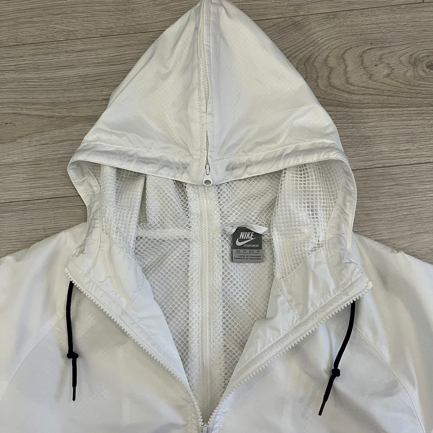 Nike Japan Olympics Split Windbreaker from 2008, created by designer Jarrett Reynolds. Crafted in white with a large red circle representing Japan’s flag, this innovative jacket can be zipped apart on both sides and merged with other compatible models. Hidden inside, a small Japan flags accent completes the concept.