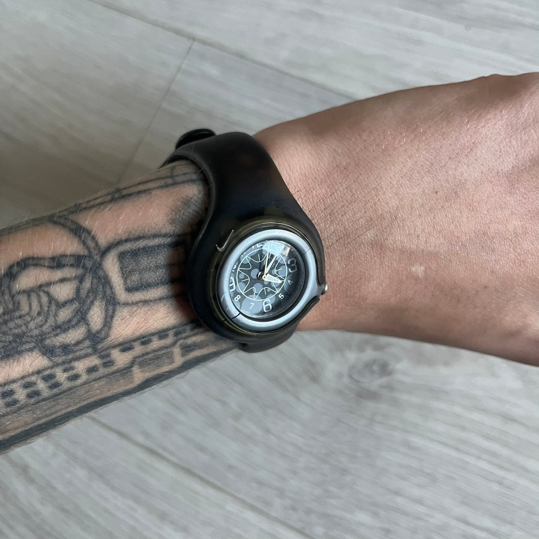 A minimalist timepiece from Nike, the Jelly Bean WK0003 stands out with its transparent dark strap filled with intentional bubble accents. The small analog face continues the theme with subtle grey bubble details, creating a sleek and unconventional design.