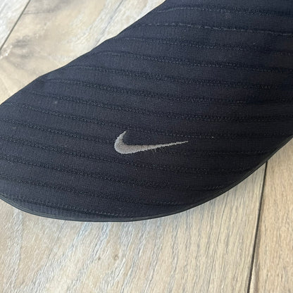 Nike Kyoto 2002 Slip-On Black Shoe is a slip-on model released in 2002, featuring a woven stretch upper with an embroidered Swoosh and stitched medial detailing. The design includes a nubuck panel with embossed Nike script and a patterned upper inspired by Zen garden textures, paired with a contrasting orange outsole. This model was part of Nike’s early performance-focused footwear line connected to yoga-inspired design.