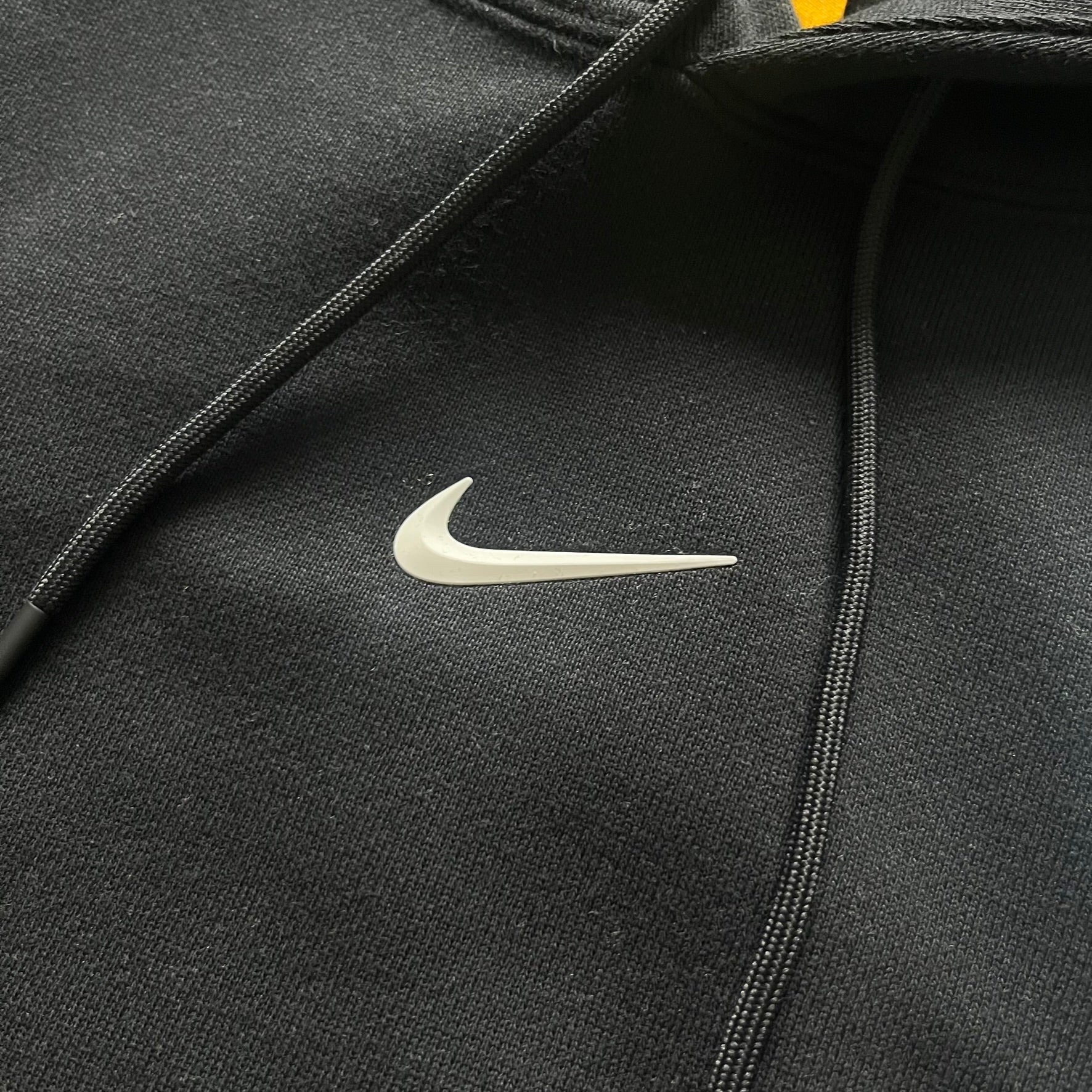 Nike x Nocta Fleece CS Hoodie in Black combines Drake’s refined streetwear vision with Nike’s premium craftsmanship. Made from an ultra-soft fleece blend, it features reflective piping, a silicone Swoosh logo and discreet NOCTA branding. With an adjustable hood, kangaroo pocket, and hidden zip pocket, this piece balances luxury comfort and technical precision.