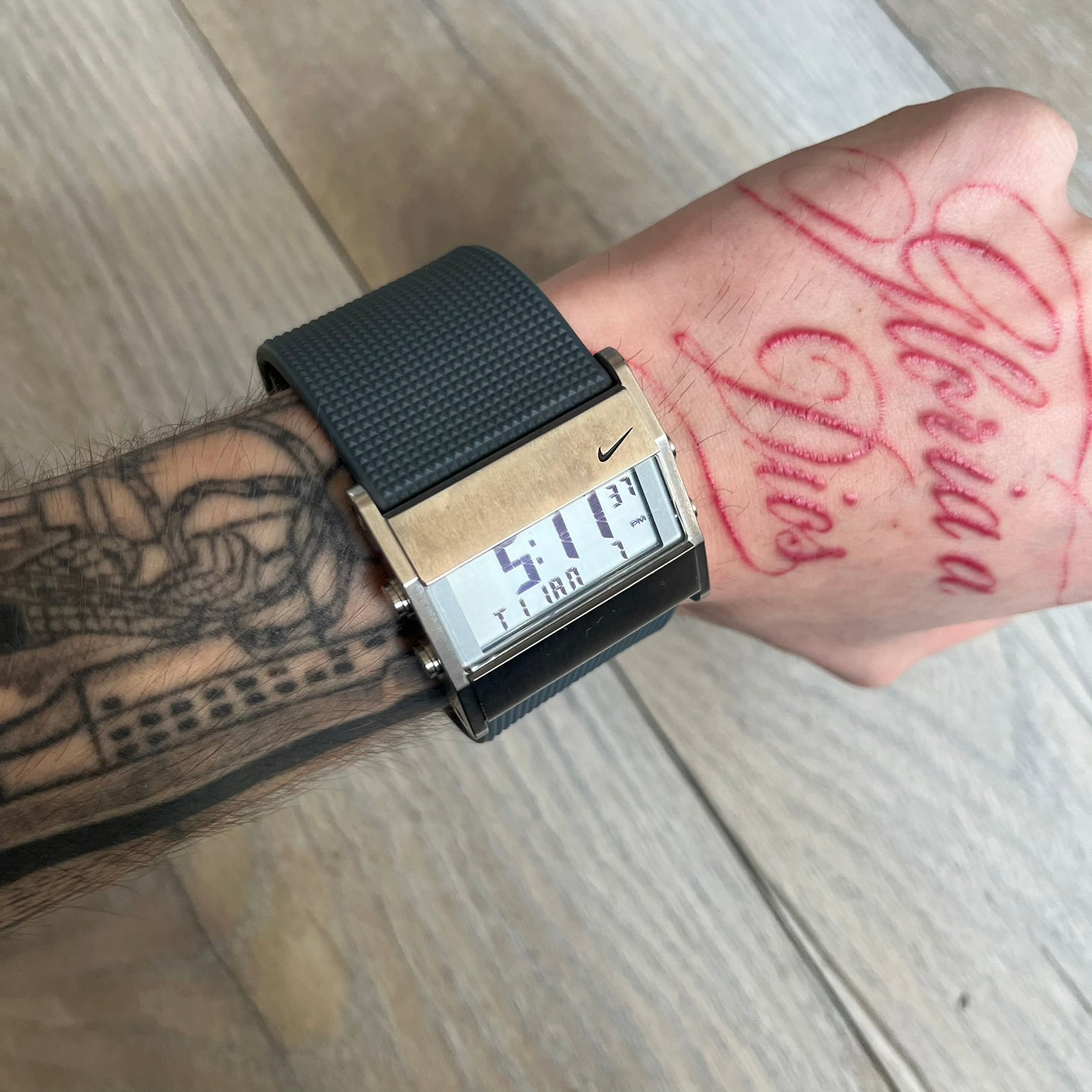 Nike Oregon Series Gray Digital Watch is a digital wristwatch featuring a rectangular display with a stainless steel frame and a dark grey rubber strap with stainless steel clasp. The watch includes four side buttons, backlight function, and displays black digital numerals, with a small Nike logo on the metal bezel. It is water resistant up to 100 meters, powered by fresh batteries, and comes with original tag and box.