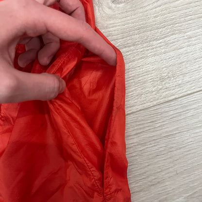 Nike Red/Blue/White Split Windbreaker featuring a modular design with front and back zippers that allow attachment to compatible jackets. The layout includes dominant red panels across the sleeves and upper front, contrasted with blue accents, a white hood, and a blue-white-black camo hood lining. Finished with a gold embroidered Nike logo on the chest.