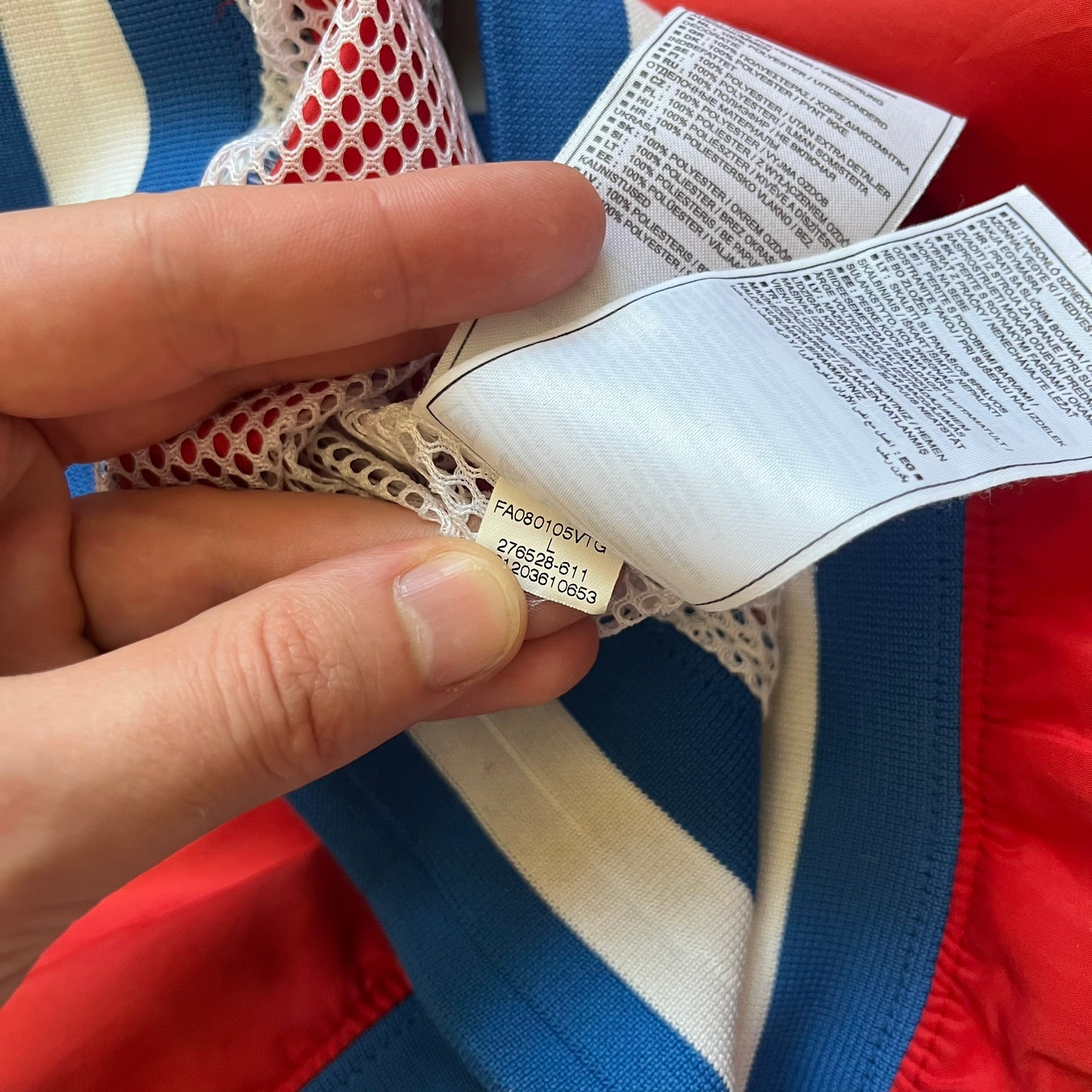 Nike Russia Olympics Split Windbreaker from 2008, created by designer Jarrett Reynolds. Crafted in a red, blue and white color wave. White Nike embroidery swoosh on the left side of the chest. The upper half of the jacket is blue with white hood, and the bottom is red with white accents. This innovative jacket can be zipped apart on both sides and merged with other compatible models. Hidden inside, a small Russia flags accent completes the concept.
