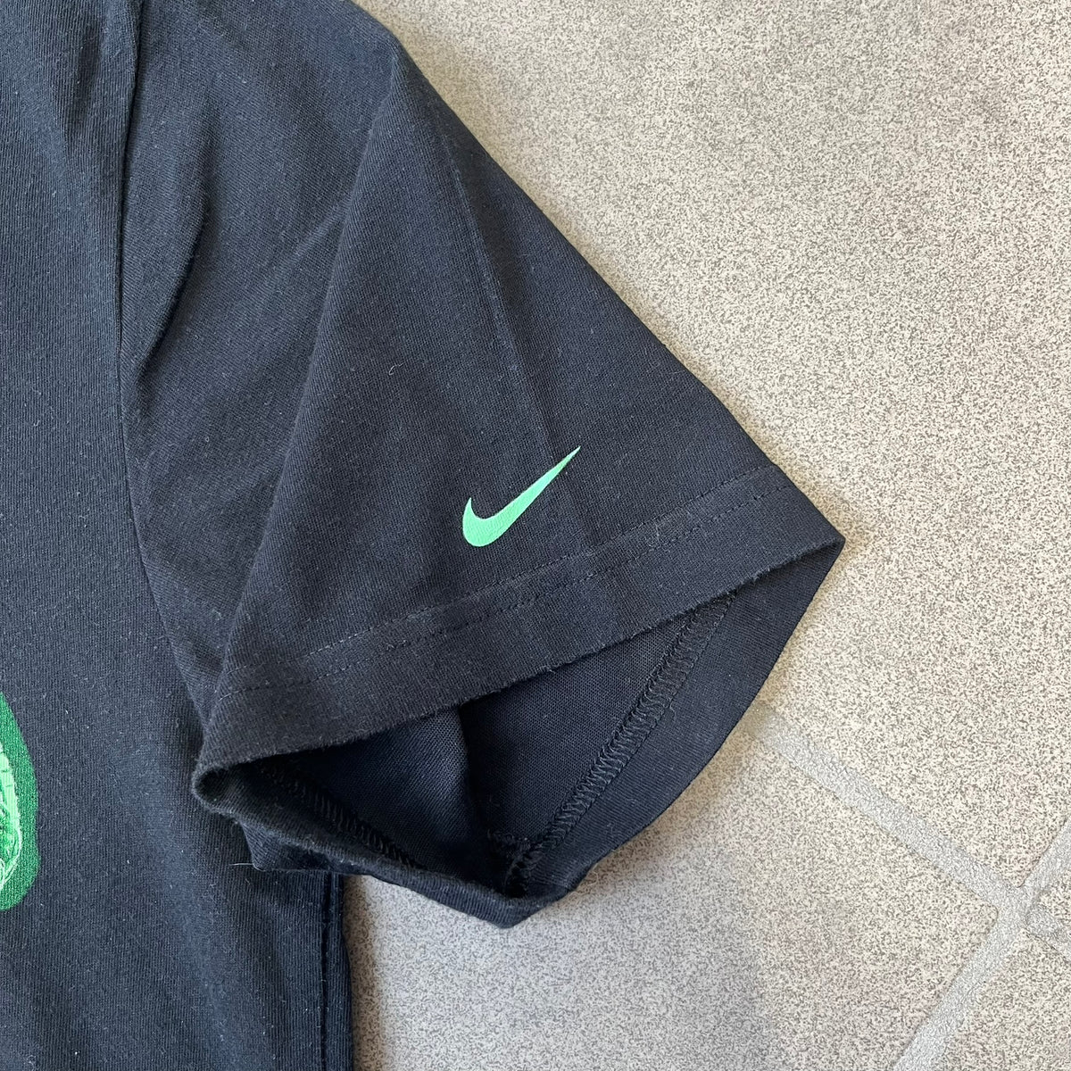 Nike SS11 "X-Ray Skeleton Free Faster" Tee is a black T-shirt from the Nike Free 2011 Spring/Summer season, designed by art director Kelvin Govey and designer Wonman Kim. The design features a large glow-in-the-dark green X-ray skeletal figure constructed entirely from parts of the Nike Free Run+2 shoe, with white Dri-FIT text at the bottom right and a green Nike Swoosh on the left sleeve.&nbsp;