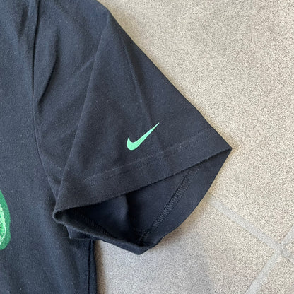 Nike SS11 "X-Ray Skeleton Free Faster" Tee is a black T-shirt from the Nike Free 2011 Spring/Summer season, designed by art director Kelvin Govey and designer Wonman Kim. The design features a large glow-in-the-dark green X-ray skeletal figure constructed entirely from parts of the Nike Free Run+2 shoe, with white Dri-FIT text at the bottom right and a green Nike Swoosh on the left sleeve.&nbsp;