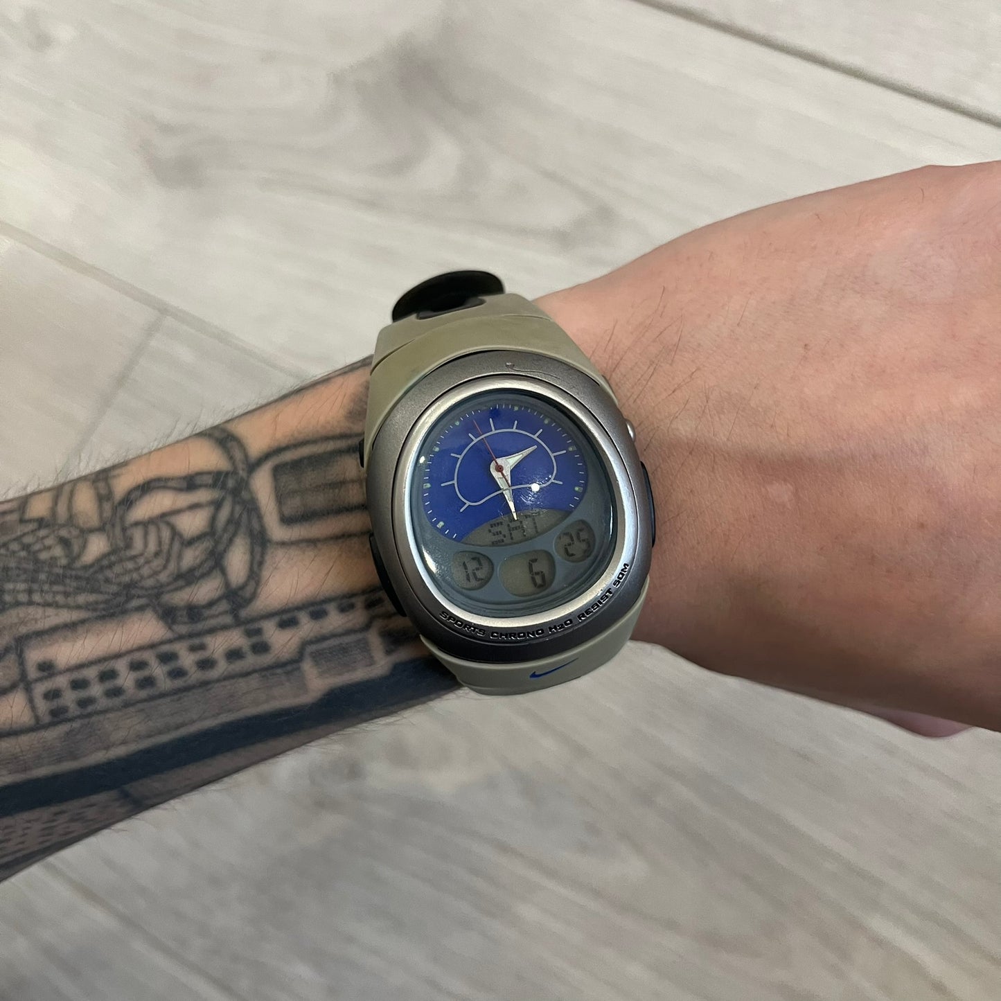 Nike Sports Chrono Cross Training Watch featuring a unique ana-digi design with a Blue Analog face. The display combines a three-hand analog setup with a curved dual-section LCD showing time, day, and mode. Water-resistant up to 50m and equipped with chronograph, timer, alarm, and dual-time functions.