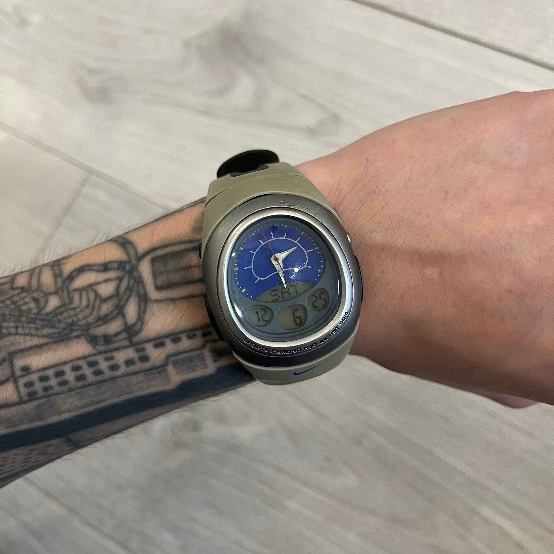 Nike Sports Chrono Cross Training Watch featuring a unique ana-digi design with a Blue Analog face. The display combines a three-hand analog setup with a curved dual-section LCD showing time, day, and mode. Water-resistant up to 50m and equipped with chronograph, timer, alarm, and dual-time functions.