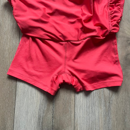 Nike Tie Break Knit 2012 Coral Tennis Skirt is a women’s tennis skort in coral featuring an integrated inner shorts layer. The skirt has a flared, creased design at the sides and a white Nike Swoosh at the lower hem. Designed for sporty performance, it combines lightweight knit construction with Nike’s 2012 Tie Break tennis line styling.
