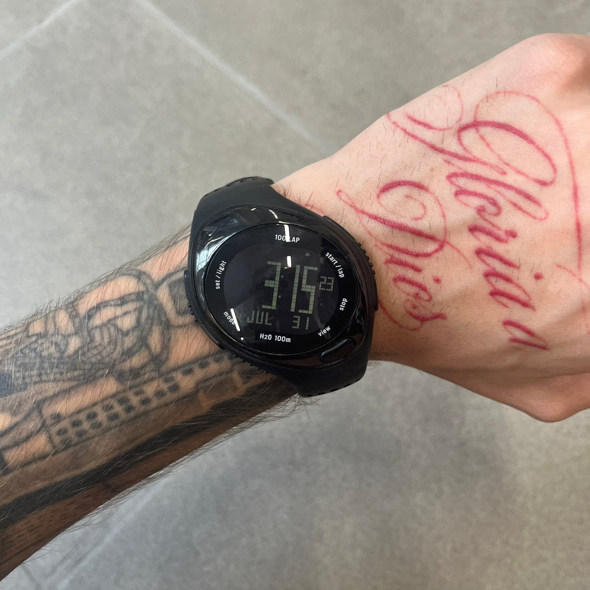 Nike Triax 2000's Bowerman Black Speed 100 Digital Watch features an all-black construction with rubber straps and a black digital display with light numerals. The case has a small Nike Swoosh at the top, while the watch includes 100-lap memory, multiple modes, and 100m water resistance.