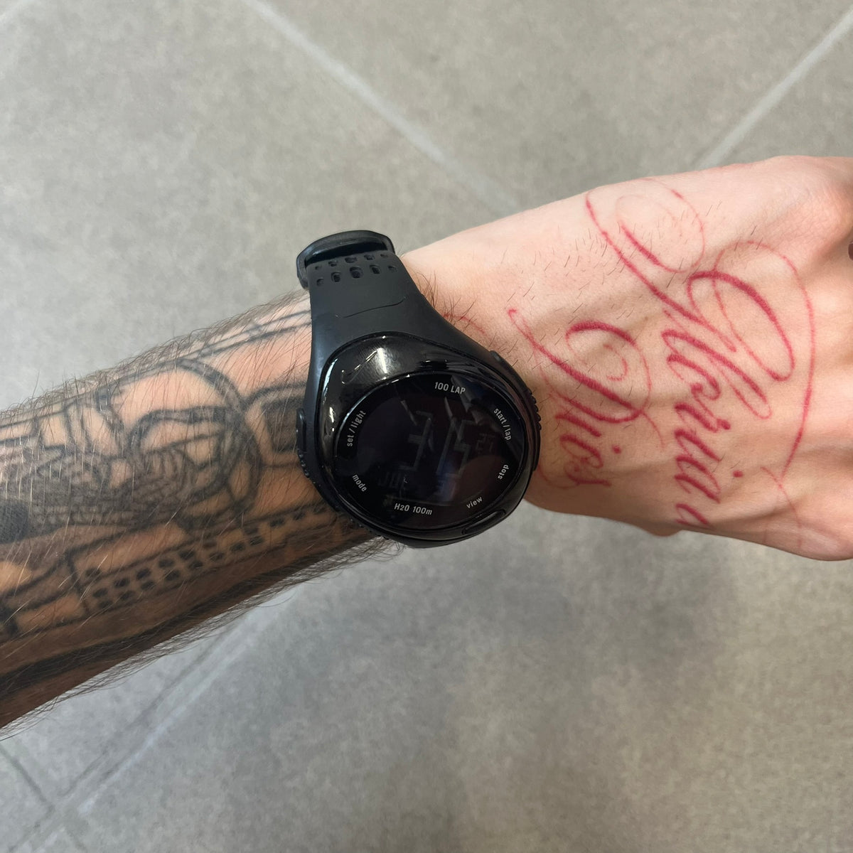 Nike Triax 2000's Bowerman Black Speed 100 Digital Watch features an all-black construction with rubber straps and a black digital display with light numerals. The case has a small Nike Swoosh at the top, while the watch includes 100-lap memory, multiple modes, and 100m water resistance.