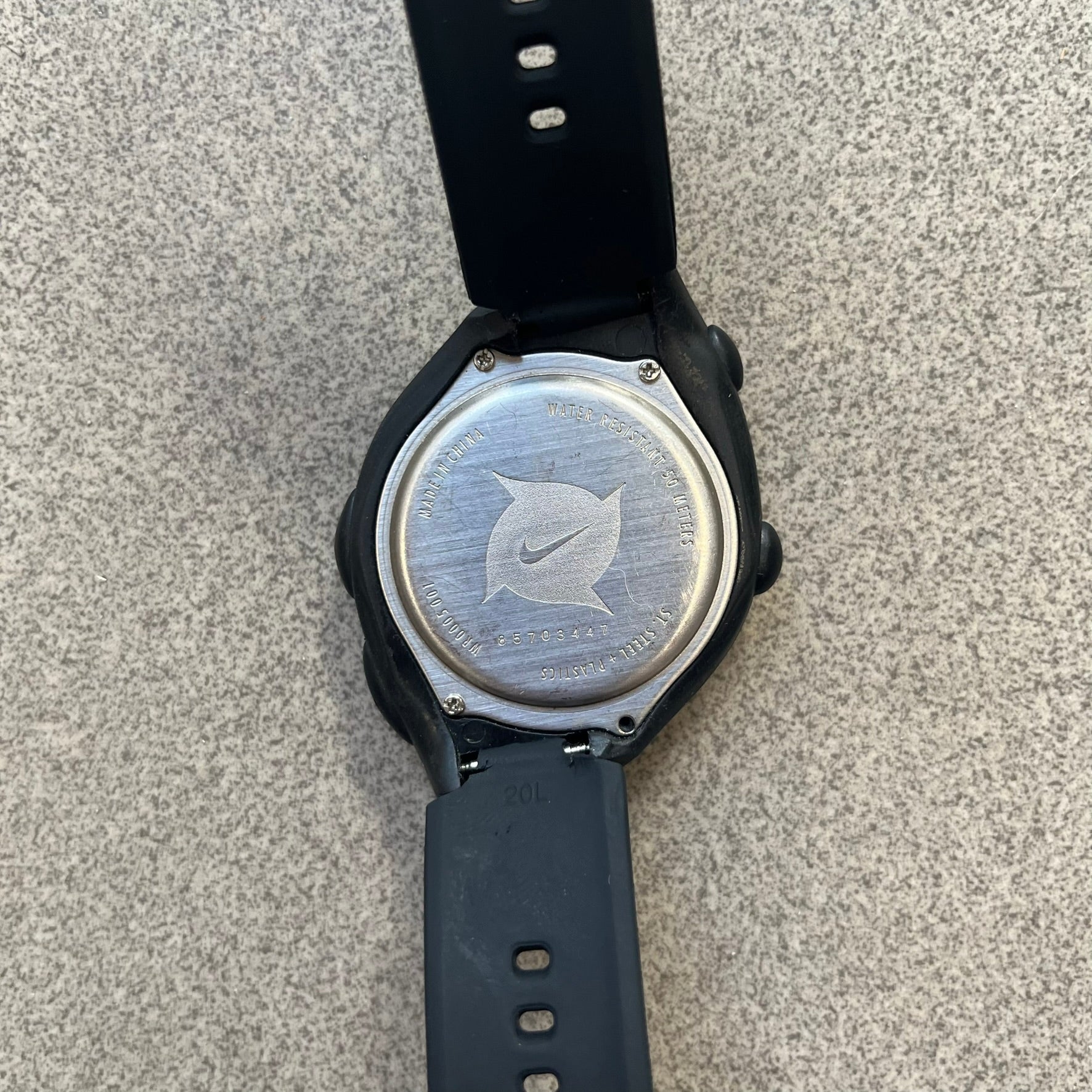 Nike Triax 2000's Super 10 Lap Digital Watch features a black case with a small white Nike Swoosh above the digital display. It has 10-lap memory, four modes, a light-up display, and water resistance. Model WR0005-001. The rubber straps have been replaced with non-original ones.
