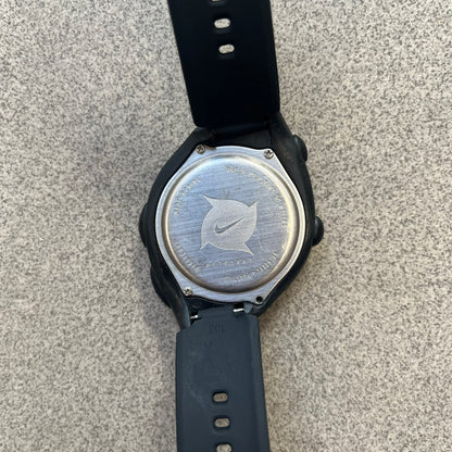 Nike Triax 2000's Super 10 Lap Digital Watch features a black case with a small white Nike Swoosh above the digital display. It has 10-lap memory, four modes, a light-up display, and water resistance. Model WR0005-001. The rubber straps have been replaced with non-original ones.
