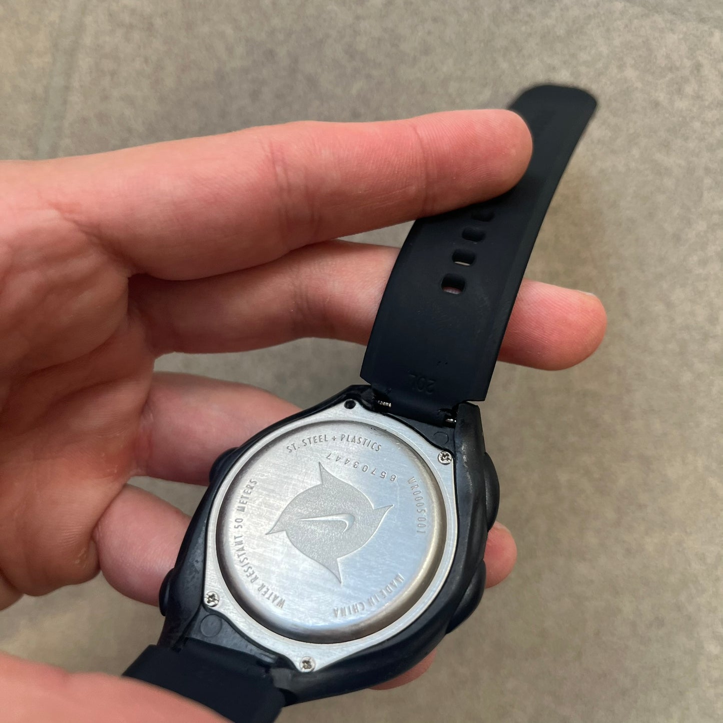 Nike Triax 2000's Super 10 Lap Digital Watch features a black case with a small white Nike Swoosh above the digital display. It has 10-lap memory, four modes, a light-up display, and water resistance. Model WR0005-001. The rubber straps have been replaced with non-original ones.
