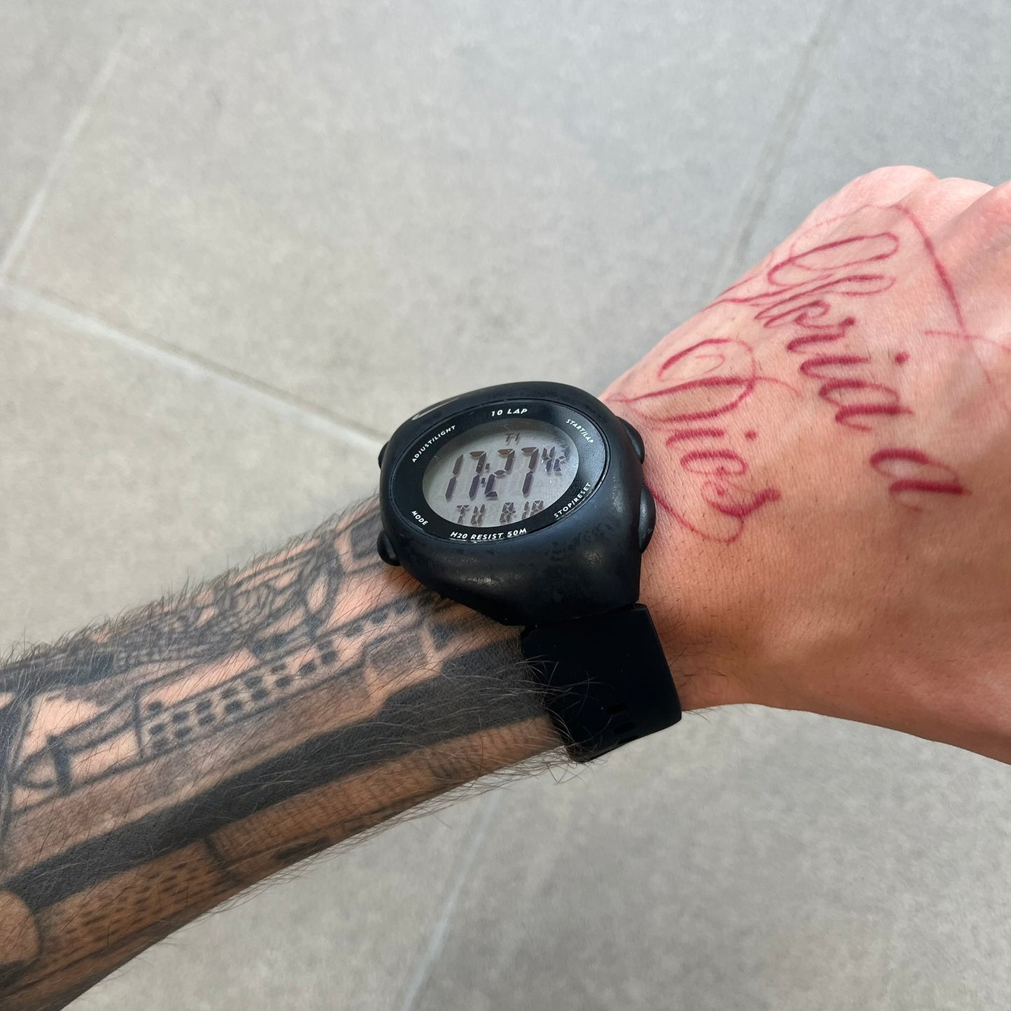 Nike Triax 2000's Super 10 Lap Digital Watch features a black case with a small white Nike Swoosh above the digital display. It has 10-lap memory, four modes, a light-up display, and water resistance. Model WR0005-001. The rubber straps have been replaced with non-original ones.
