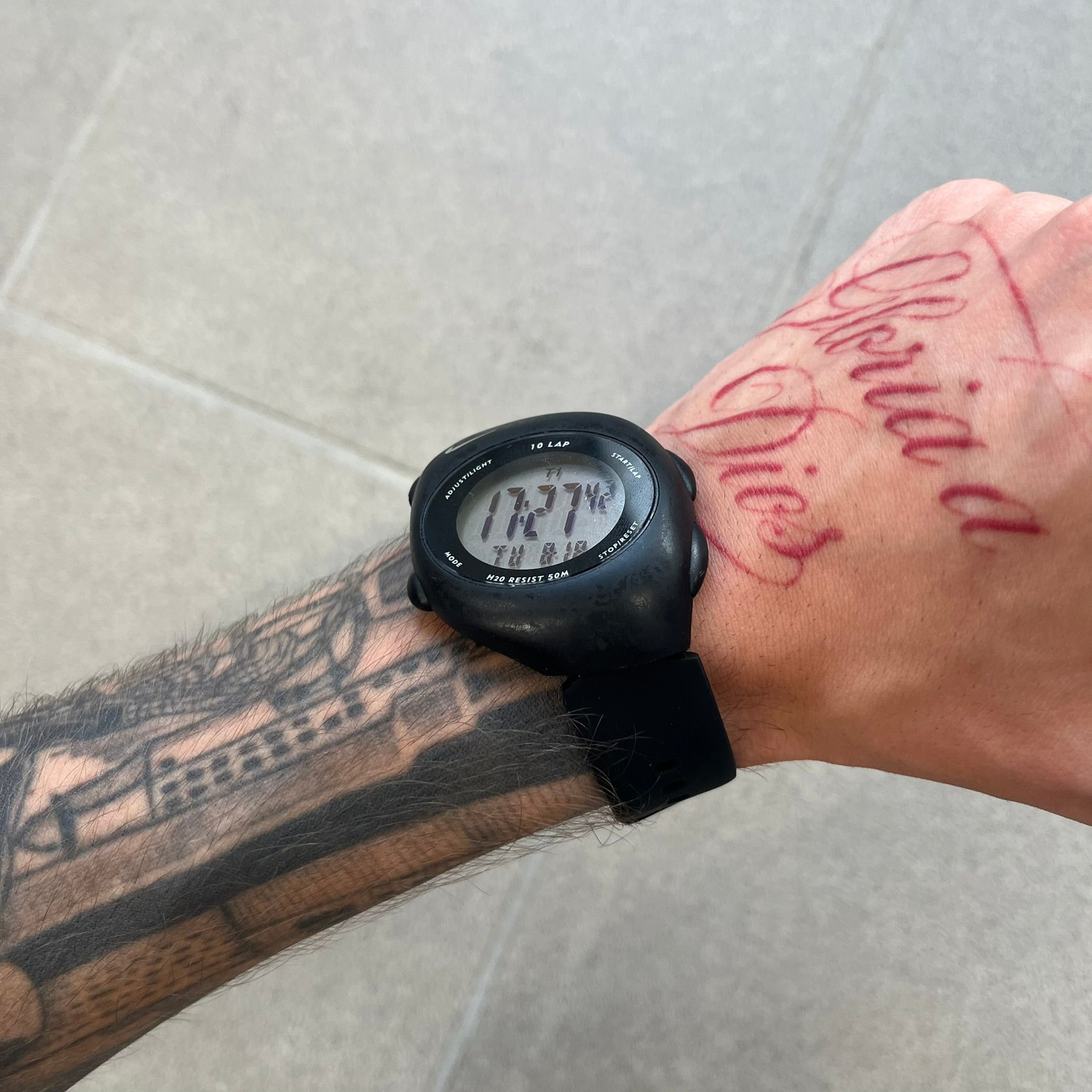 Nike Triax 2000's Super 10 Lap Digital Watch features a black case with a small white Nike Swoosh above the digital display. It has 10-lap memory, four modes, a light-up display, and water resistance. Model WR0005-001. The rubber straps have been replaced with non-original ones.
