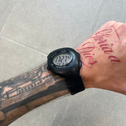 Nike Triax 2000's Super 10 Lap Digital Watch features a black case with a small white Nike Swoosh above the digital display. It has 10-lap memory, four modes, a light-up display, and water resistance. Model WR0005-001. The rubber straps have been replaced with non-original ones.

