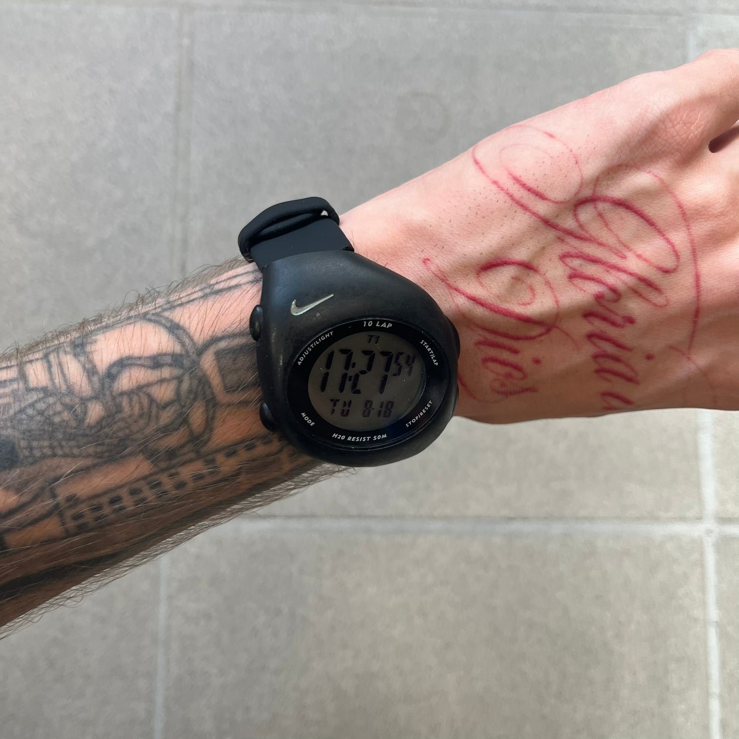 Nike Triax 2000's Super 10 Lap Digital Watch features a black case with a small white Nike Swoosh above the digital display. It has 10-lap memory, four modes, a light-up display, and water resistance. Model WR0005-001. The rubber straps have been replaced with non-original ones.
