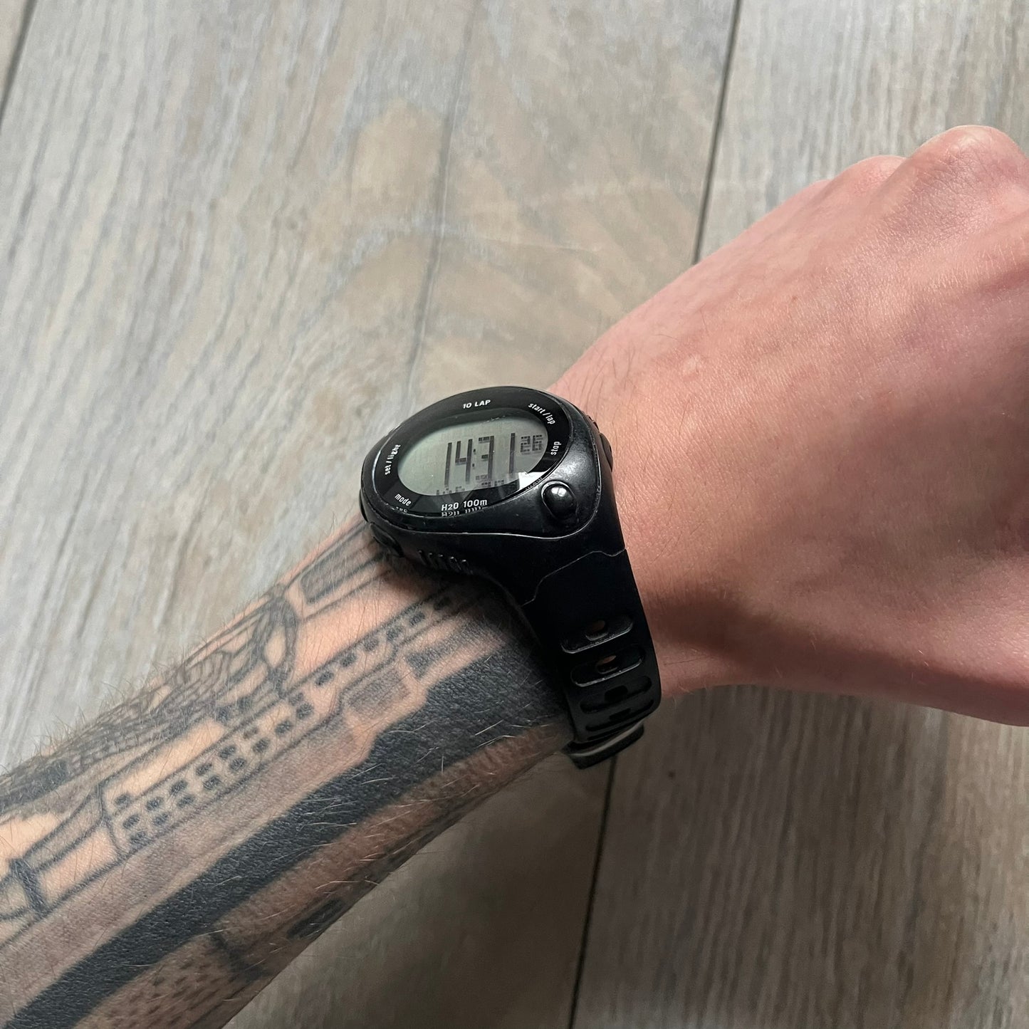 The Nike Triax Bowerman WR0124 Black Digital Watch features black rubber straps and a black plastic case with a metal caseback engraved with the Bowerman logo. It includes a digital display with multiple modes, a 10-lap memory function, H2O 100 water resistance, and a built-in backlight. The watch has a single front button and a white Nike logo on the case.