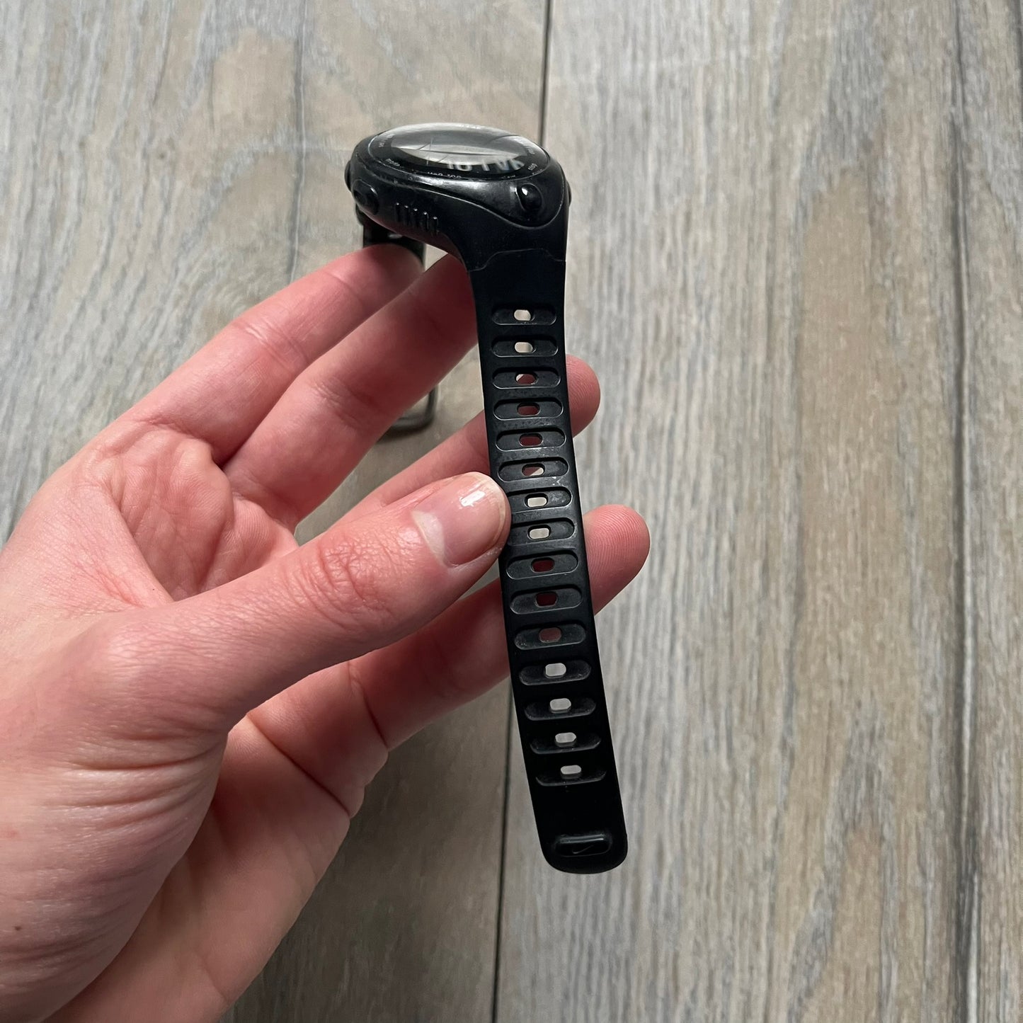 The Nike Triax Bowerman WR0124 Black Digital Watch features black rubber straps and a black plastic case with a metal caseback engraved with the Bowerman logo. It includes a digital display with multiple modes, a 10-lap memory function, H2O 100 water resistance, and a built-in backlight. The watch has a single front button and a white Nike logo on the case.