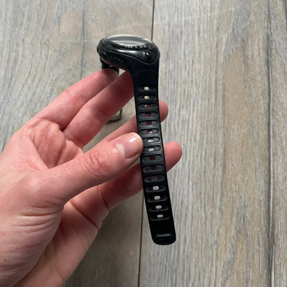 The Nike Triax Bowerman WR0124 Black Digital Watch features black rubber straps and a black plastic case with a metal caseback engraved with the Bowerman logo. It includes a digital display with multiple modes, a 10-lap memory function, H2O 100 water resistance, and a built-in backlight. The watch has a single front button and a white Nike logo on the case.