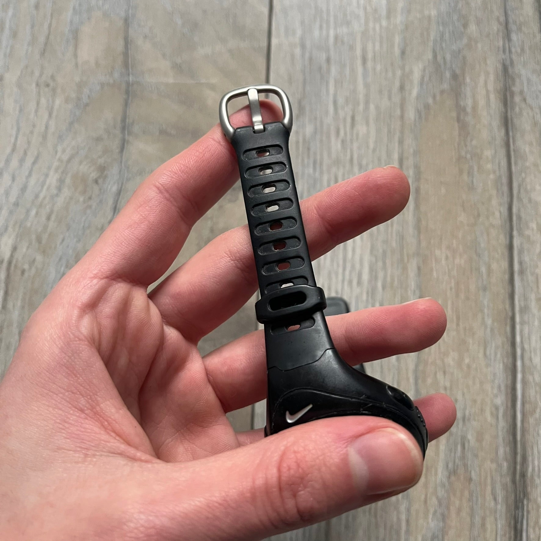 The Nike Triax Bowerman WR0124 Black Digital Watch features black rubber straps and a black plastic case with a metal caseback engraved with the Bowerman logo. It includes a digital display with multiple modes, a 10-lap memory function, H2O 100 water resistance, and a built-in backlight. The watch has a single front button and a white Nike logo on the case.