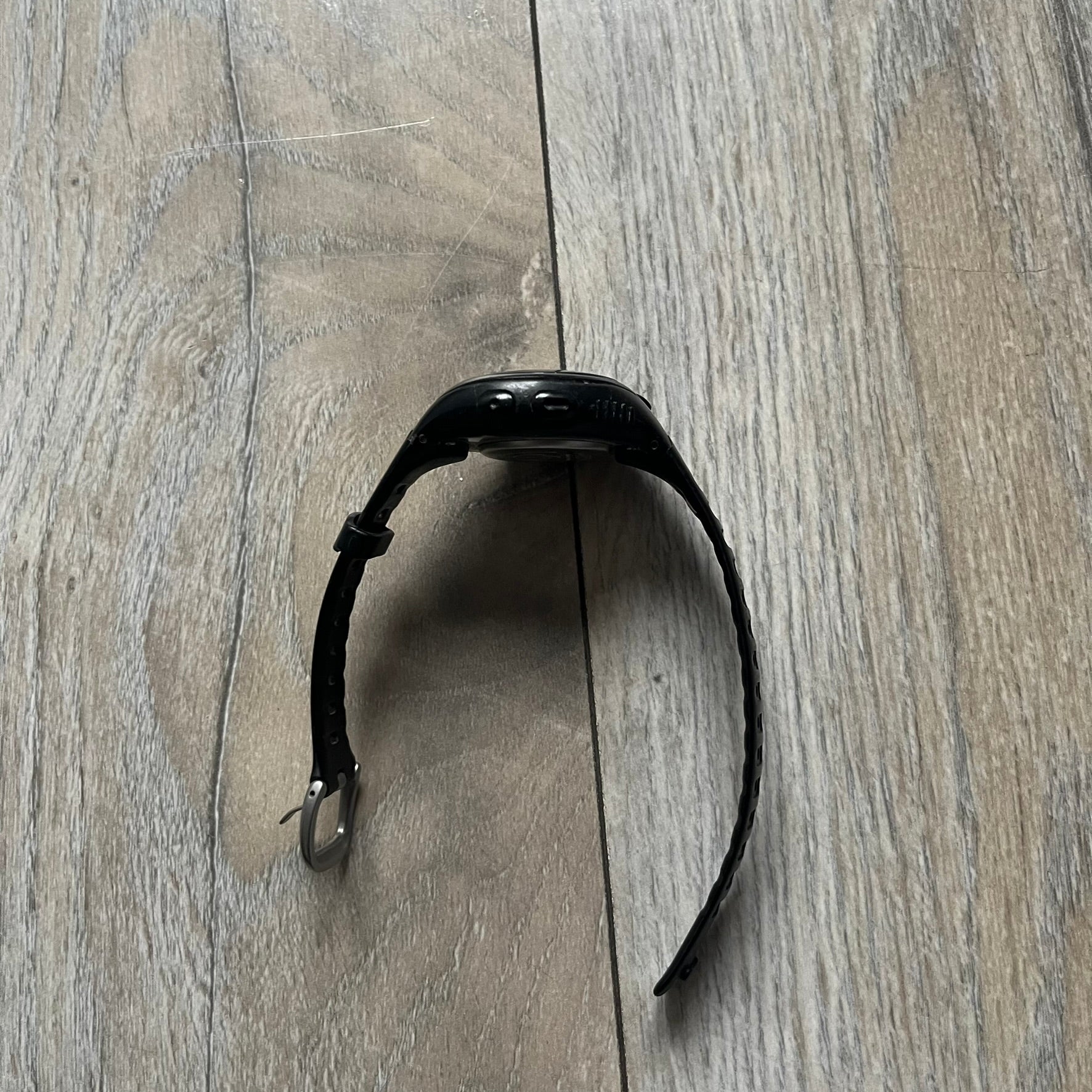 The Nike Triax Bowerman WR0124 Black Digital Watch features black rubber straps and a black plastic case with a metal caseback engraved with the Bowerman logo. It includes a digital display with multiple modes, a 10-lap memory function, H2O 100 water resistance, and a built-in backlight. The watch has a single front button and a white Nike logo on the case.