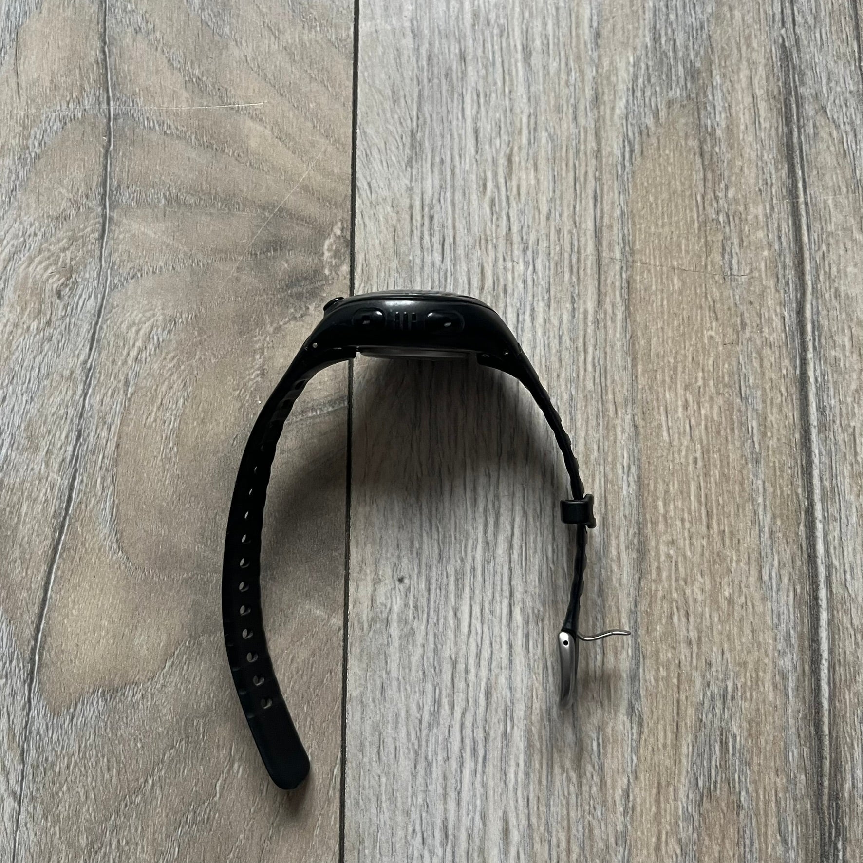 The Nike Triax Bowerman WR0124 Black Digital Watch features black rubber straps and a black plastic case with a metal caseback engraved with the Bowerman logo. It includes a digital display with multiple modes, a 10-lap memory function, H2O 100 water resistance, and a built-in backlight. The watch has a single front button and a white Nike logo on the case.