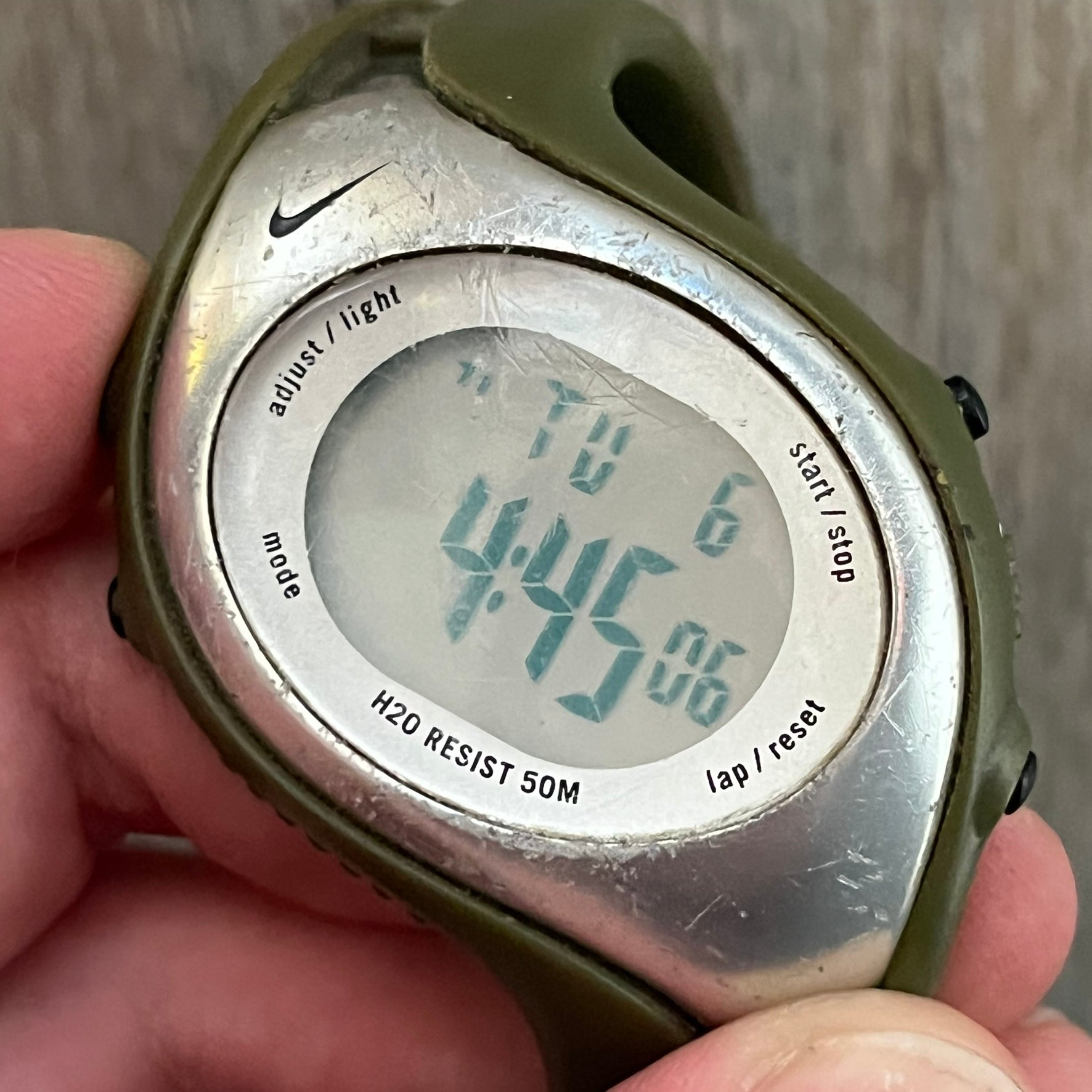 Nike Triax Fly WK0006 Green Digital Watch is a 2000s digital watch featuring a green rubber strap and silver-tone case. It includes multifunction quartz movement, a digital display with backlight functionality, and 50 meter water resistance.
