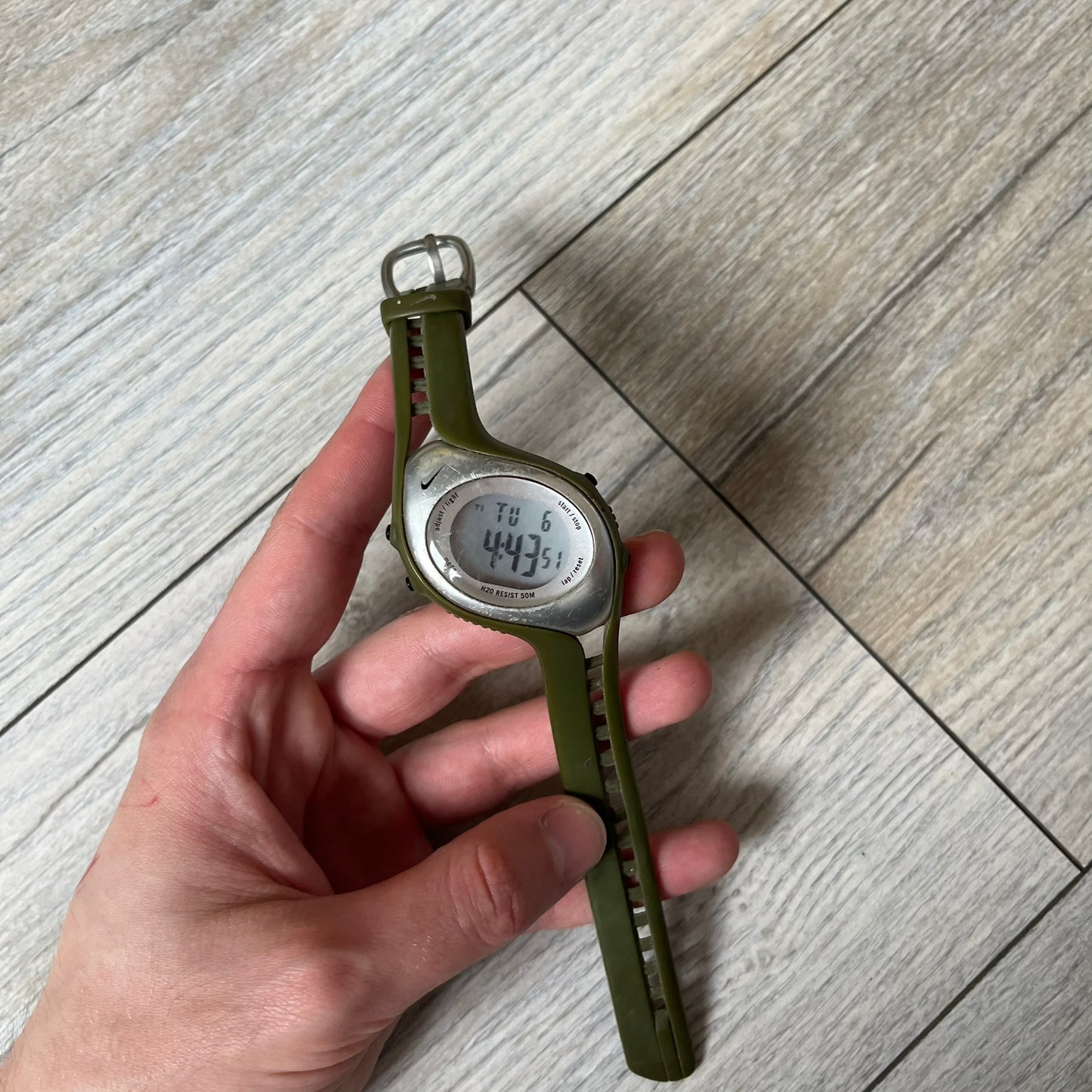 Nike Triax Fly WK0006 Green Digital Watch is a 2000s digital watch featuring a green rubber strap and silver-tone case. It includes multifunction quartz movement, a digital display with backlight functionality, and 50 meter water resistance.