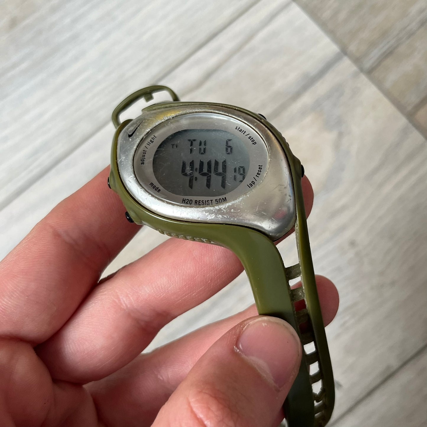 Nike Triax Fly WK0006 Green Digital Watch is a 2000s digital watch featuring a green rubber strap and silver-tone case. It includes multifunction quartz movement, a digital display with backlight functionality, and 50 meter water resistance.