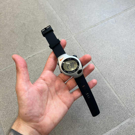 Nike Triax Regular 20 Silver Analog Watch features a silver-tone case with four black side buttons and a front button for the backlight function. The watch has an orange Nike Swoosh on the top of the case, 20-lap memory, multiple modes, and 100m water resistance. It comes with black replacement straps that are not original Nike.
