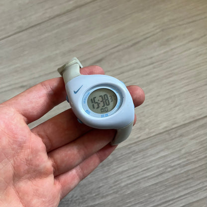 Rare late-1990s Nike Triax Roar J digital watch in a white/milky colorway with blue accents. Features an asymmetrical, ergonomic case and sporty design with a milky rubber band. The strap was broken so it needs fixing, making this either for display or restoration.