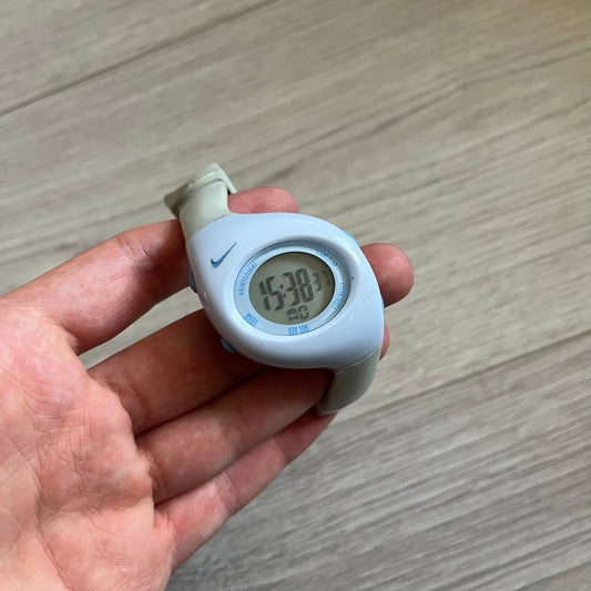 Rare late-1990s Nike Triax Roar J digital watch in a white/milky colorway with blue accents. Features an asymmetrical, ergonomic case and sporty design with a milky rubber band. The strap was broken so it needs fixing, making this either for display or restoration.