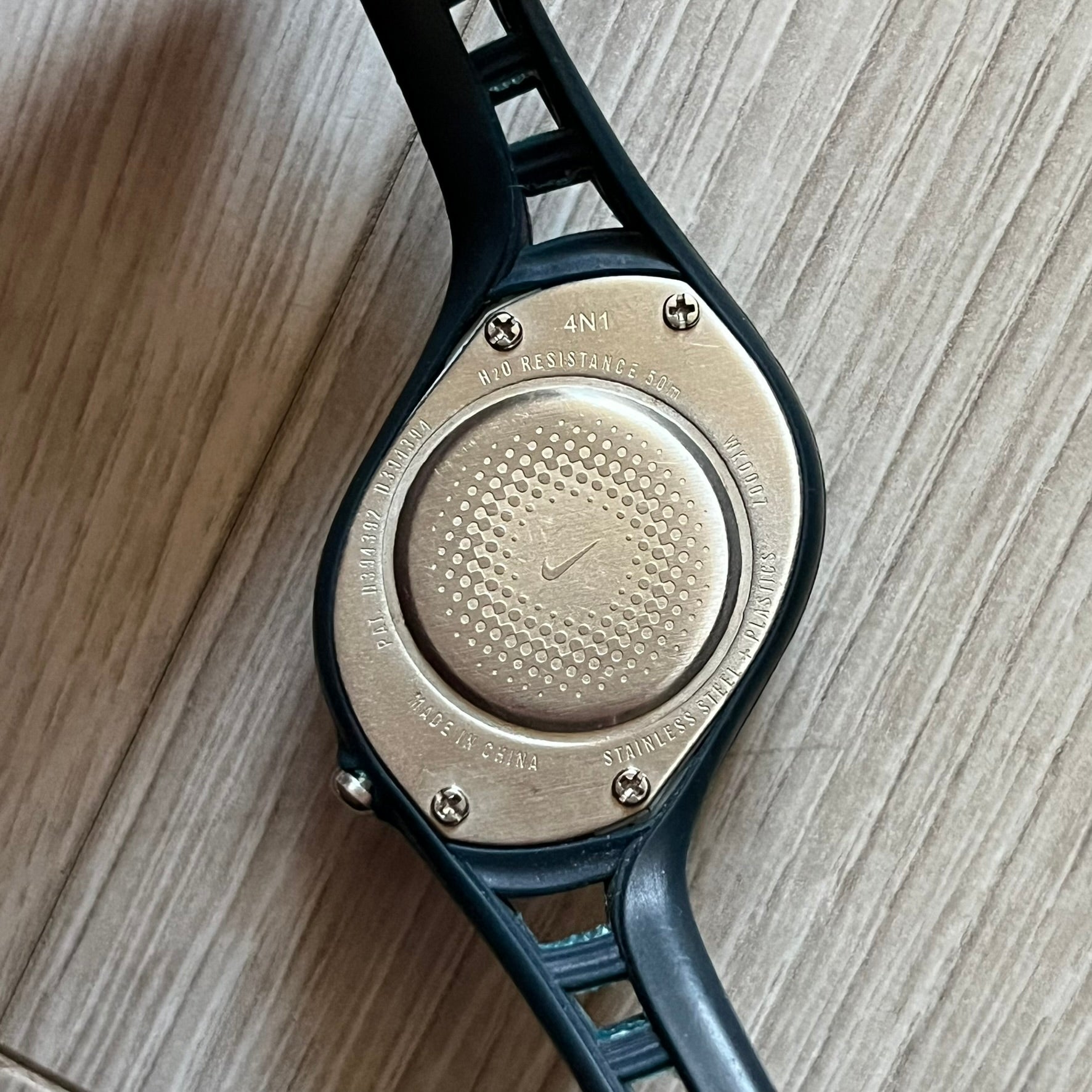 Nike Triax Roar Junior WK0007 analog watch featuring a navy rubber strap with matching navy case sides and a silver-tone front case. The metallic blue dial has a high-shine finish, silver hour markers, and silver hands for clear visibility. Built with stainless steel and metal components, the watch is water resistant up to 50 meters