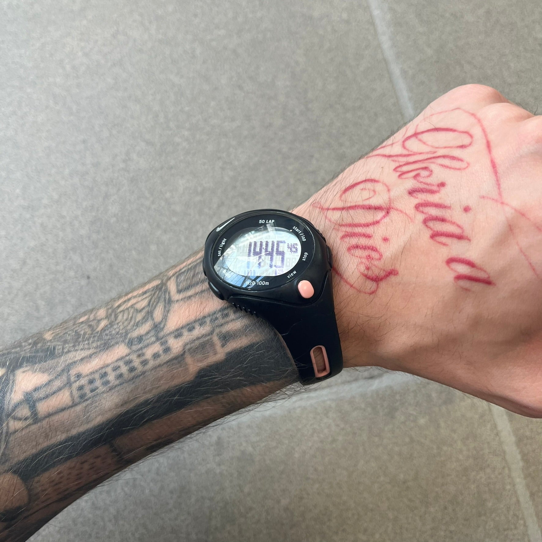 Nike Triax Speed 50 Regular Pink Digital Watch features a black case with four black side buttons and a pink-ish front button for the backlight function. The watch has an white Nike Swoosh on the top of the case, 50-lap memory, multiple modes, and 100m water resistance.